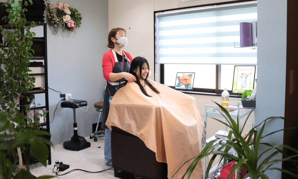鹿島市美容室テルハナのオーナースタイリストと美しいモデル女性のカウンセリング中の写真